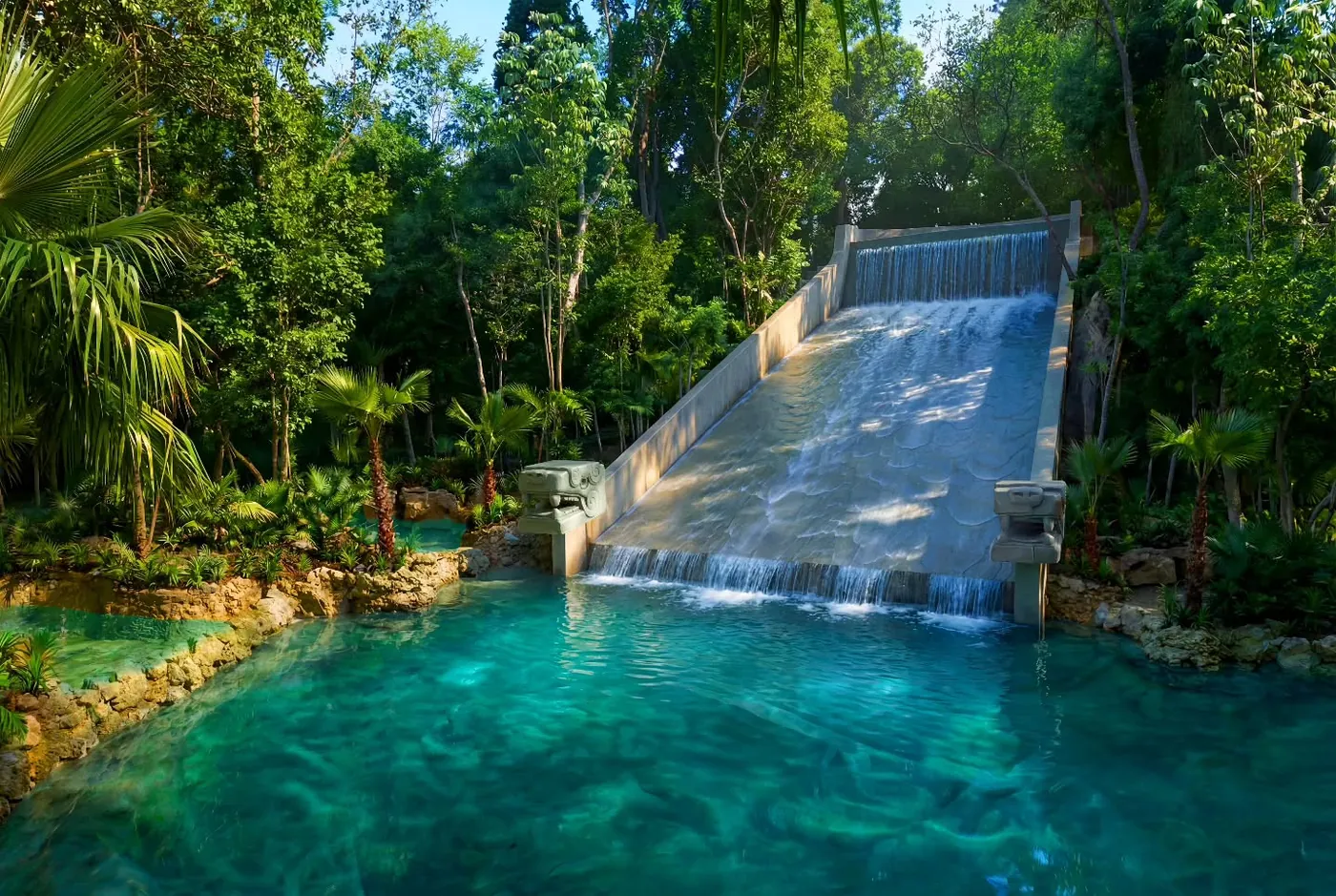 El tobogán de la pirámide termina en una alberca de agua cristalina en la selva